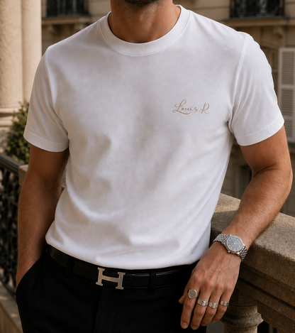 Un homme portant le T shirt Blanc Louis.R avec le logo dorée s'accoudant dans les rues de Paris.